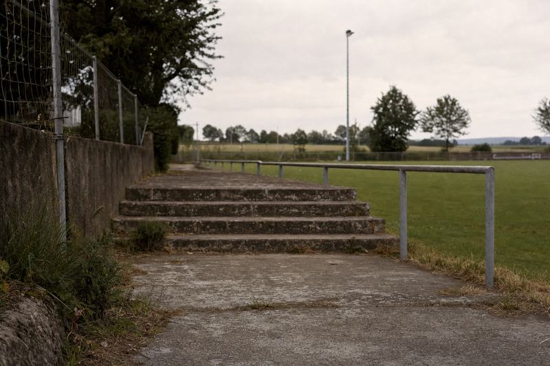 Leere Betonstufen einer kleinen Stehplatztribüne an einem Amateurplatz