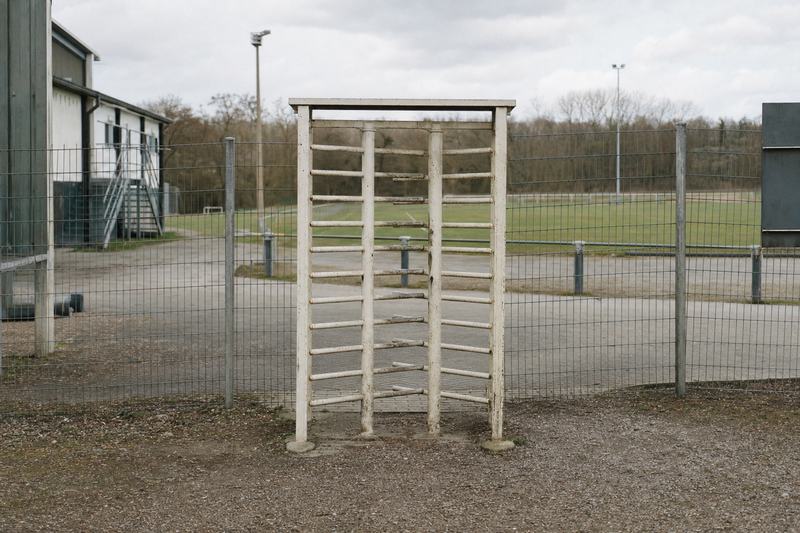 Lackiertes Drehkreuz in einem Zaun am Eingang eines kleinen Stadions